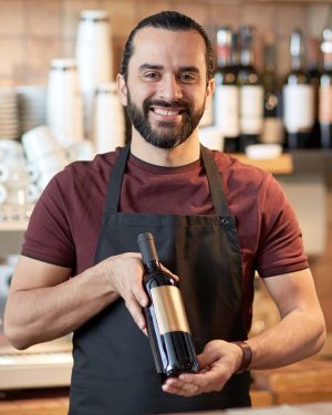 happy-man-or-waiter-with-bottle-of-red-wine-at-bar-PJD9688.jpg